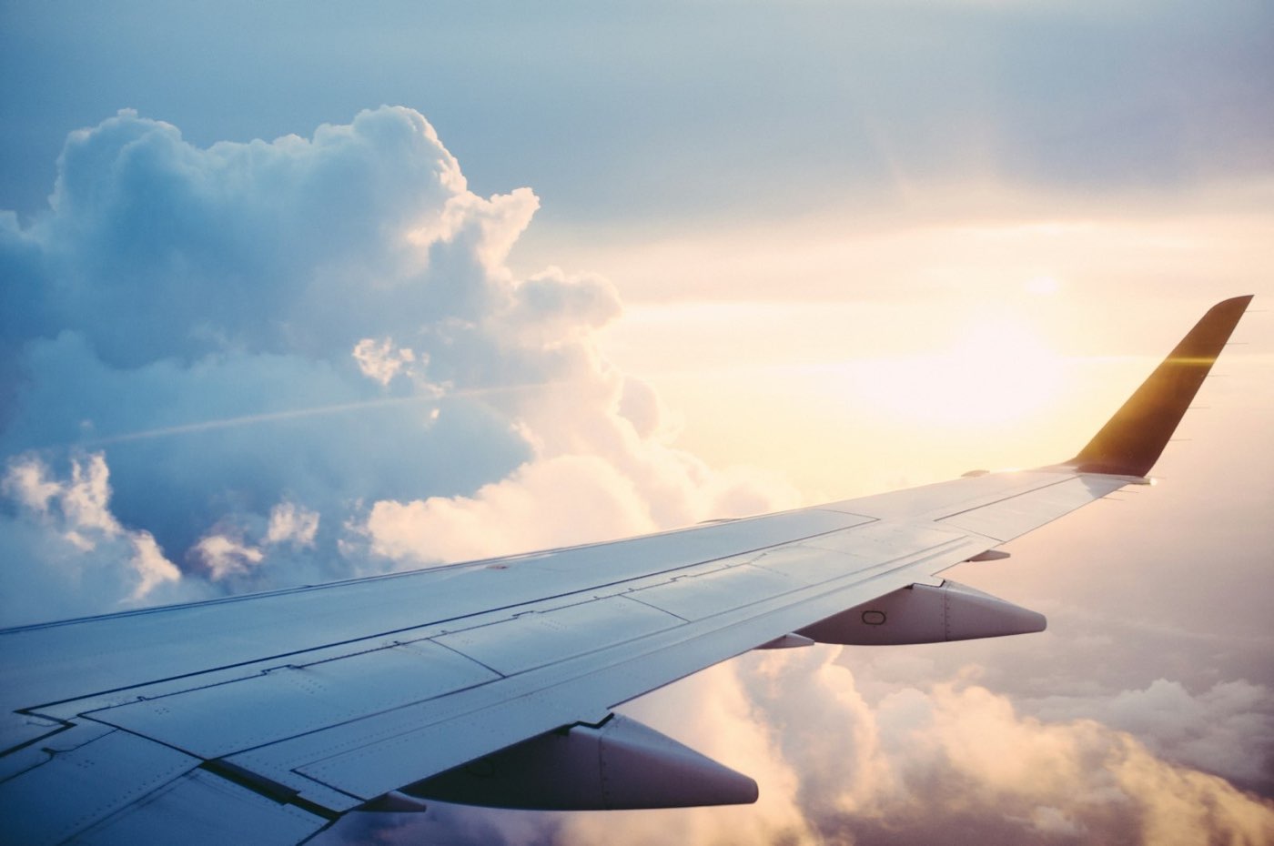 Aeroplane wing above the clouds at sunset